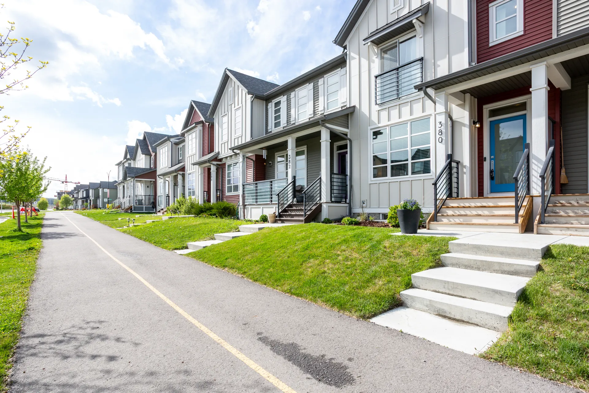 Paired homes with front porches along a pathway in Belmont, Calgary SW