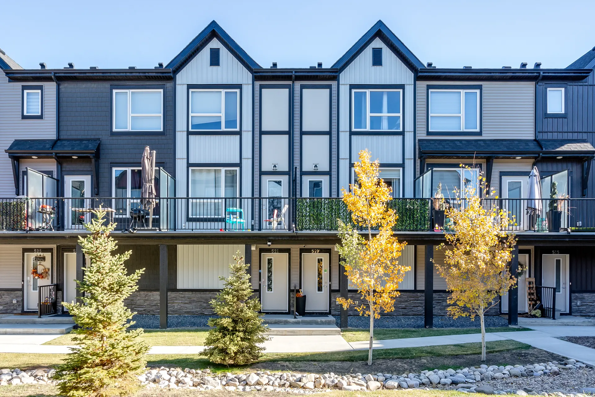 Three-storey townhomes with autumn trees on Belmont Drive SW, Calgary