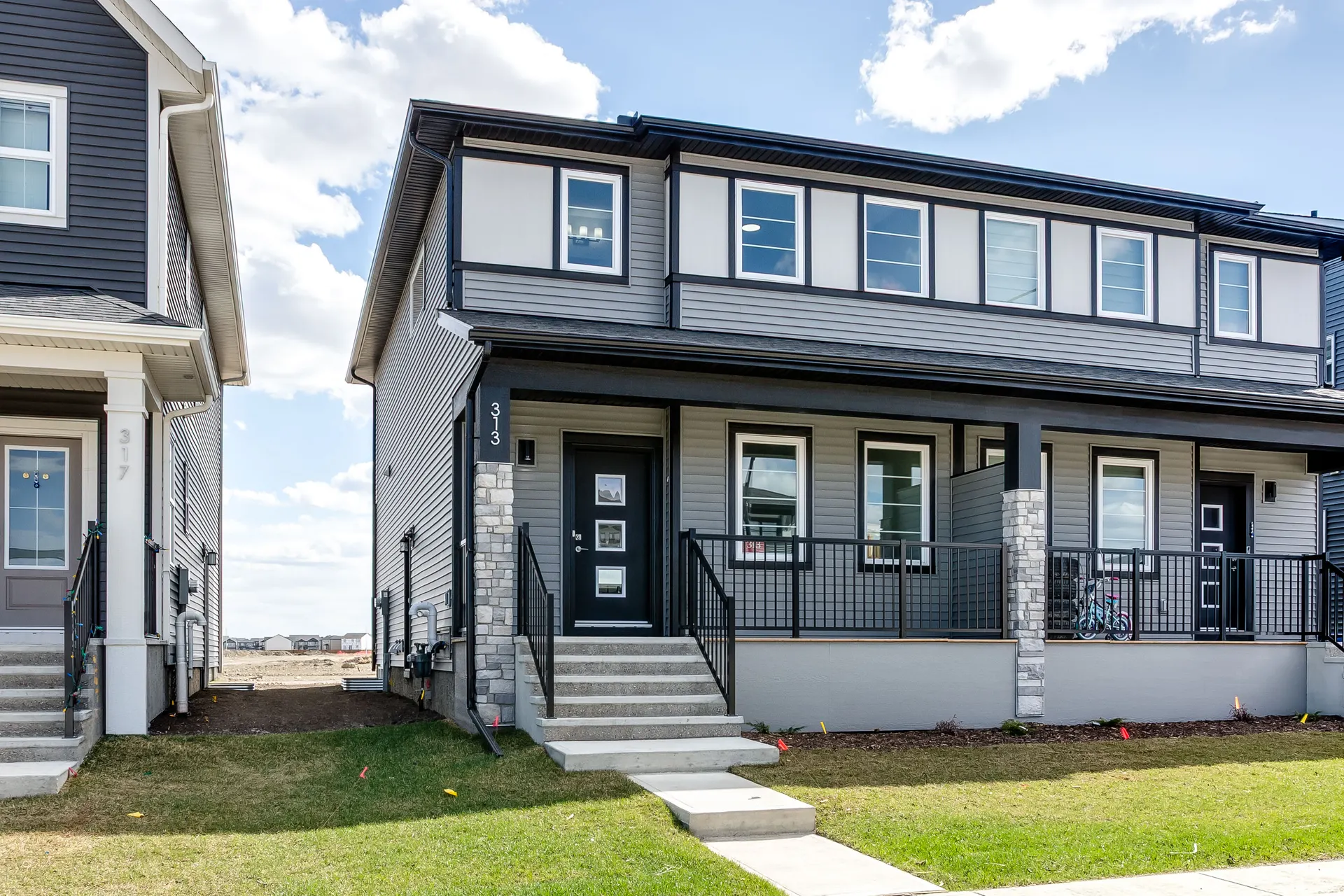 Front porch and stone-accented entry of a paired home in Cobblestone Creek, Airdrie