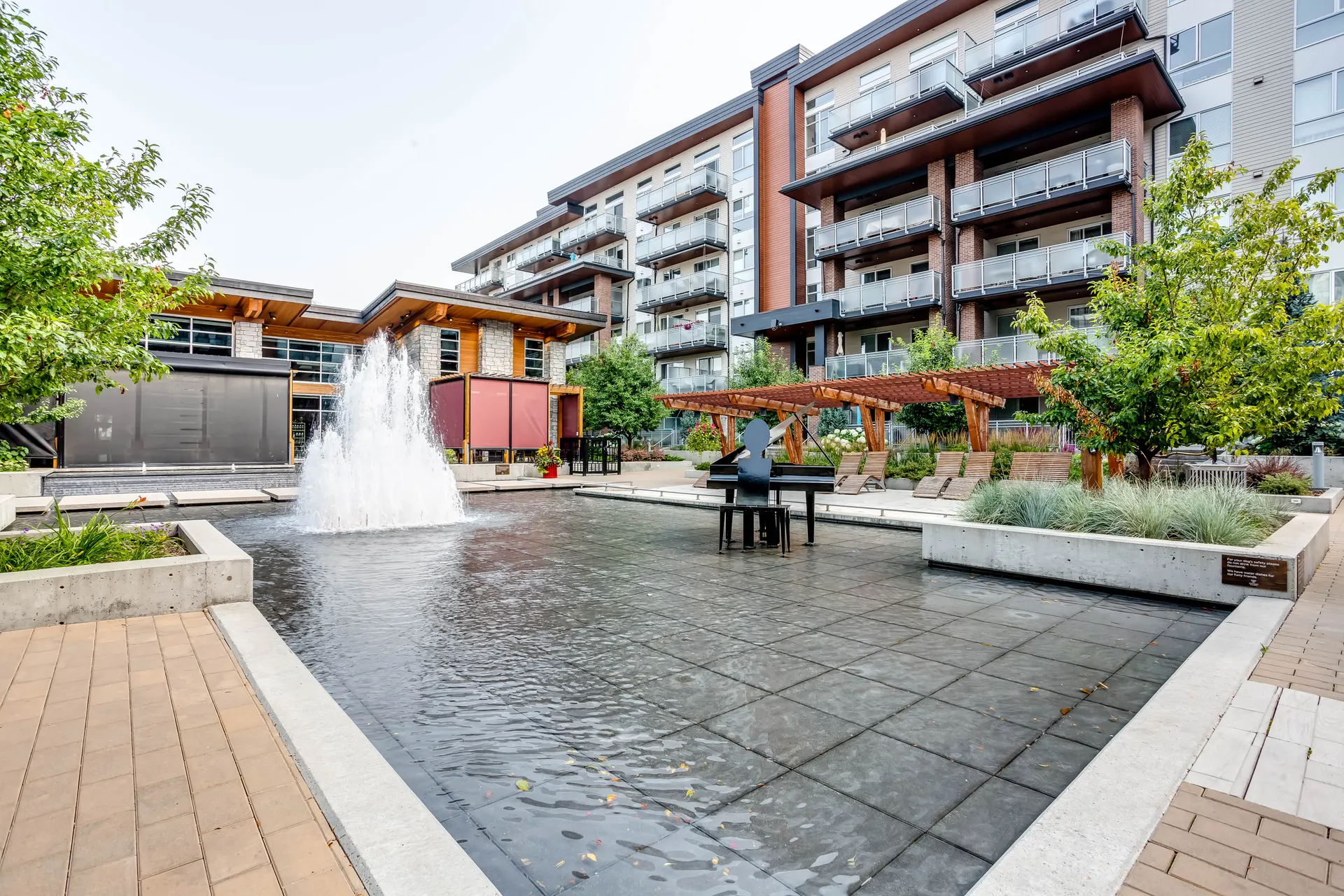 Fountain plaza between mid-rise residential buildings in Westman Village, Mahogany, Calgary SE