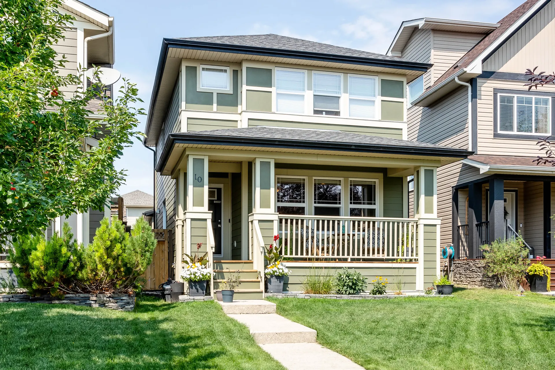 Front-drive homes along a tree-lined street in Walden, Calgary SE